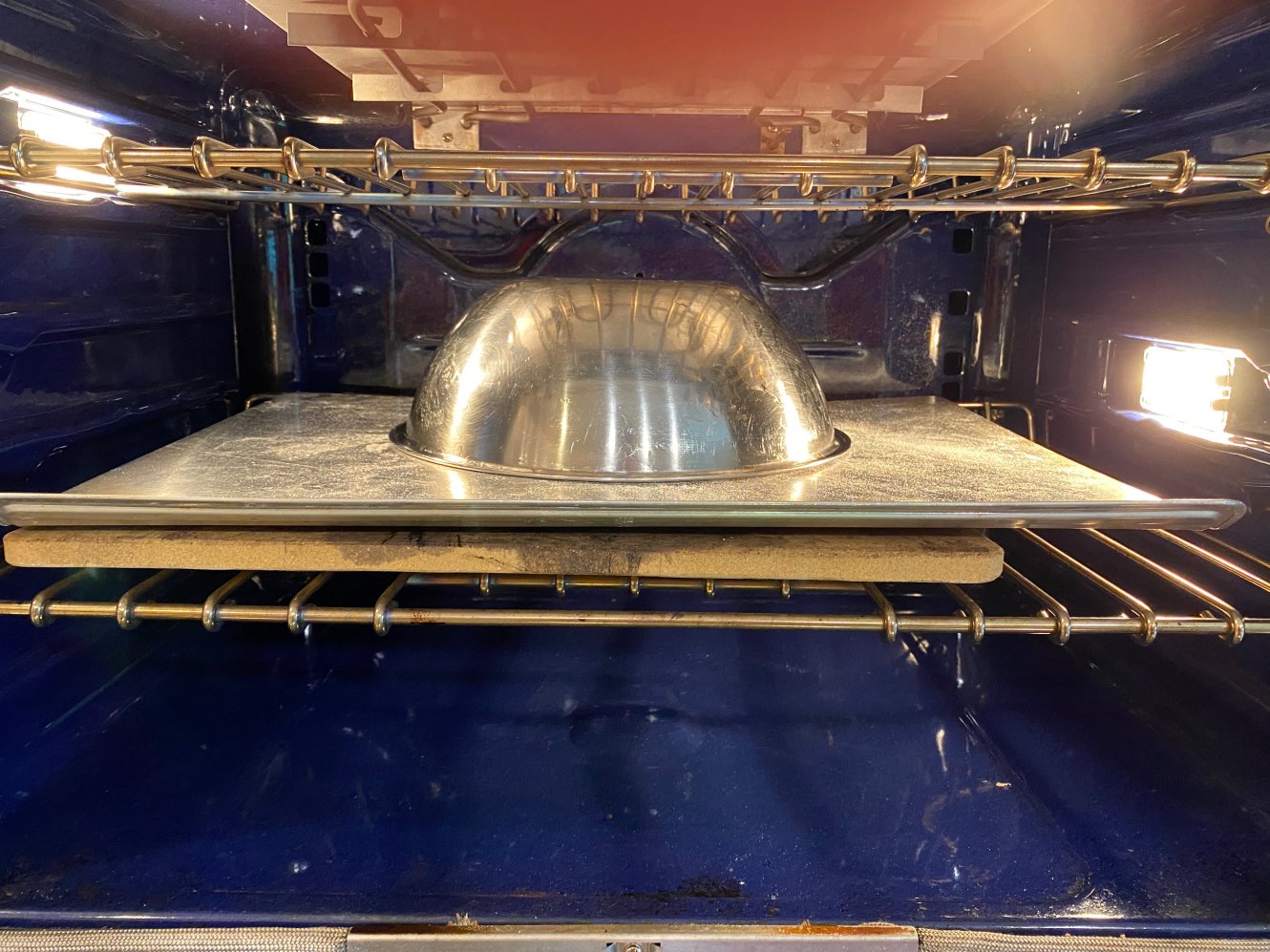 Dough in oven covered by bowl